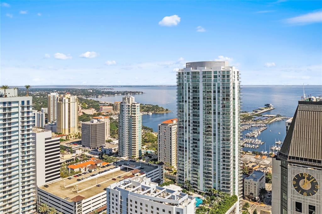 An aerial view shows high-rise apartment buildings and a marina along a waterfront — 100 1ST AVENUE N UNIT 2902, ST PETERSBURG, FL
