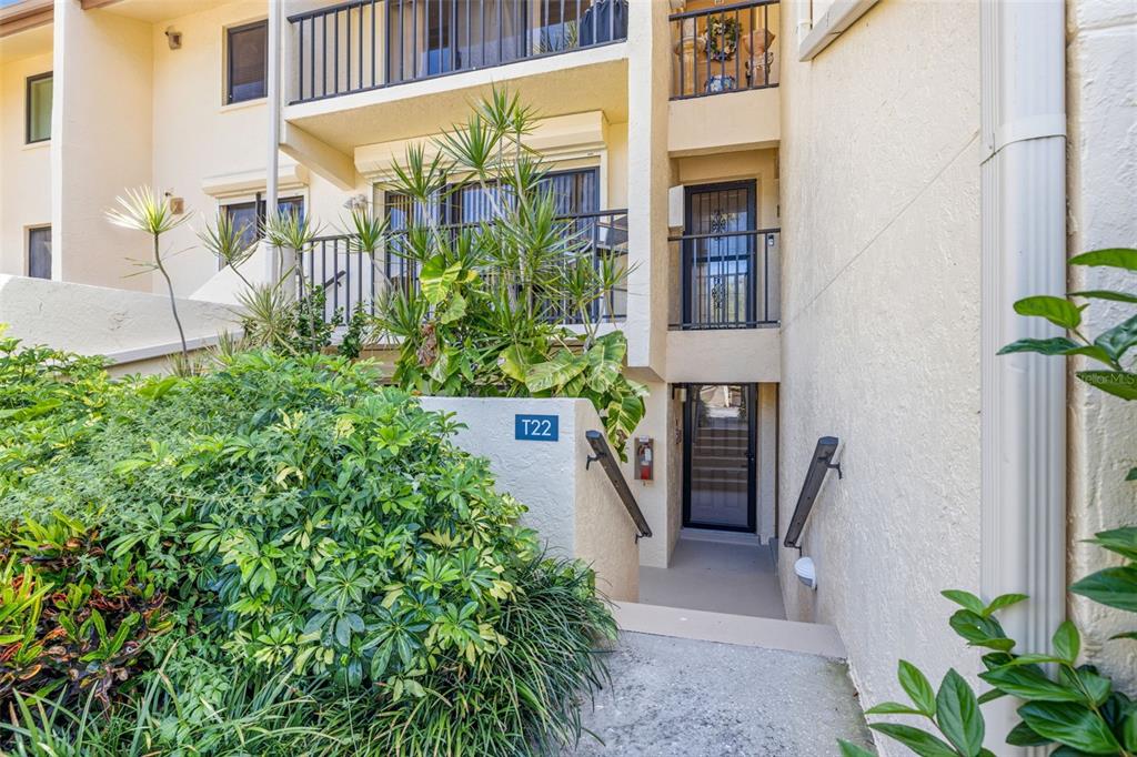 An exterior view of a multi-story building with a recessed entryway and a T22 sign — 7520 SUNSHINE SKYWAY LANE S UNIT T22, ST PETERSBURG, FL