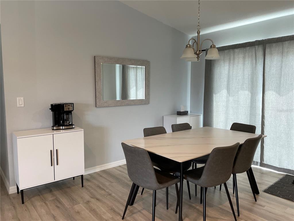 A dining room features a marble-top table, grey chairs, a white cabinet, and a mirror — 16060 SW 23RD COURT ROAD, OCALA, FL