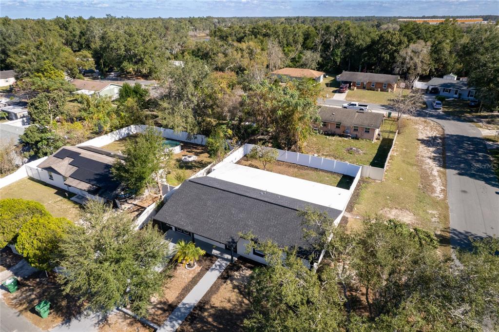 An aerial view shows a house with a dark roof and a fenced backyard — 5248 KING STREET, ZEPHYRHILLS, FL