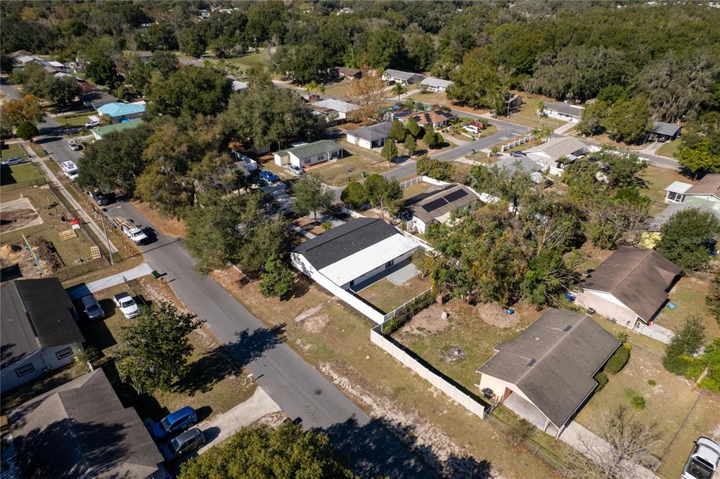 An aerial view shows a residential neighborhood with houses, streets, and surrounding trees — 5248 KING STREET, ZEPHYRHILLS, FL