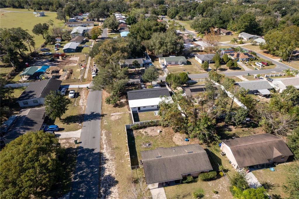 An aerial view shows a residential neighborhood with houses, trees, and a paved street — 5248 KING STREET, ZEPHYRHILLS, FL