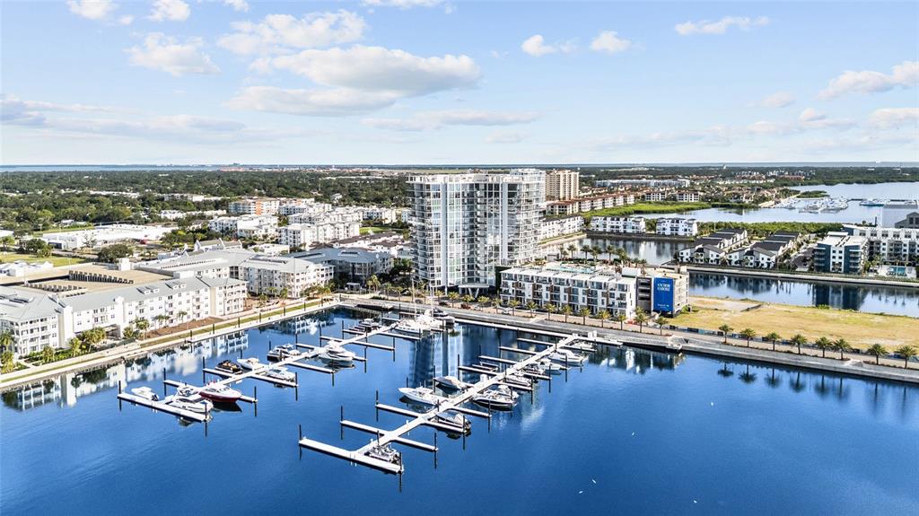 An aerial view shows a marina with docked boats next to modern apartment buildings — 5120 MARINA WAY BOAT SLIP UNIT D-W-07, TAMPA, FL