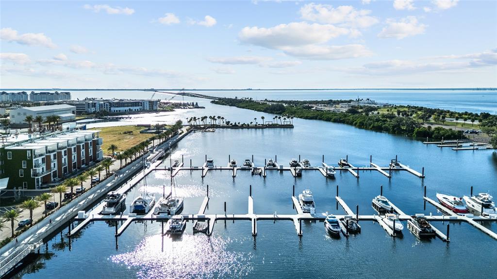 An aerial view shows a marina with numerous docked boats beside a modern apartment complex — 5120 MARINA WAY BOAT SLIP UNIT D-W-07, TAMPA, FL