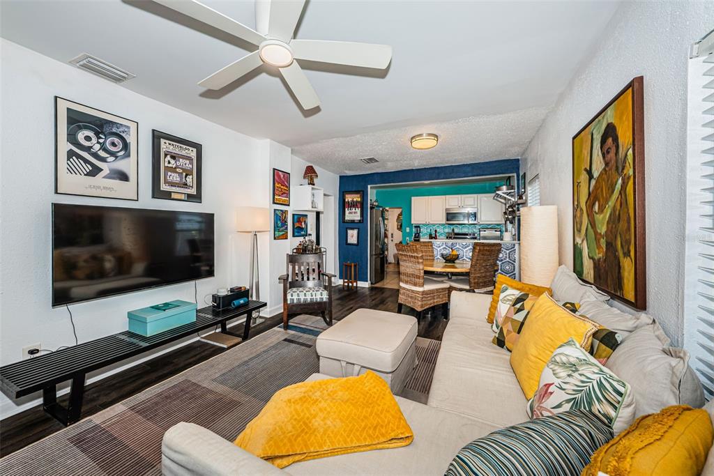 A living room features a sectional sofa, television, ceiling fan, and an adjacent dining area — 547 15TH STREET N, ST PETERSBURG, FL