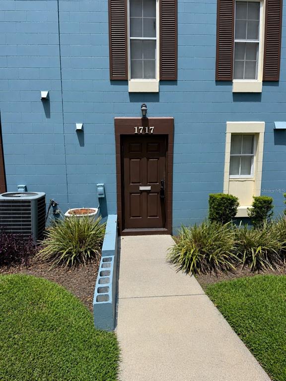 A blue concrete block building exterior features a brown front door with the number 1717 — 1717-1717 NE 2ND STREET, OCALA, FL