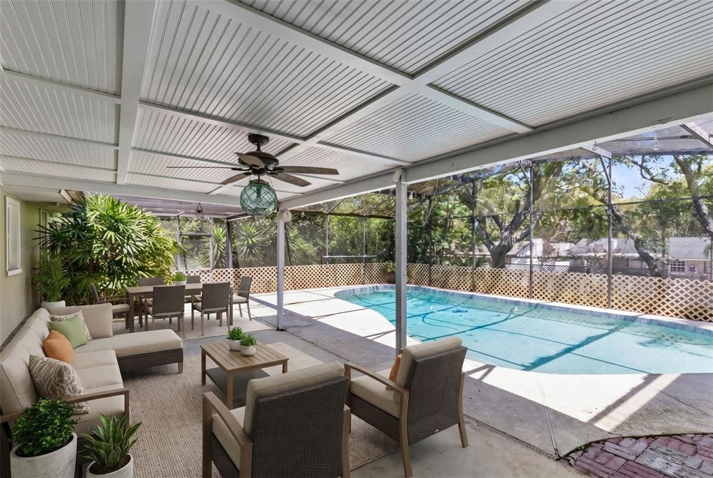 A covered patio features outdoor furniture, a ceiling fan, and a screened-in swimming pool — 2611 TAMERA COURT, APOPKA, FL