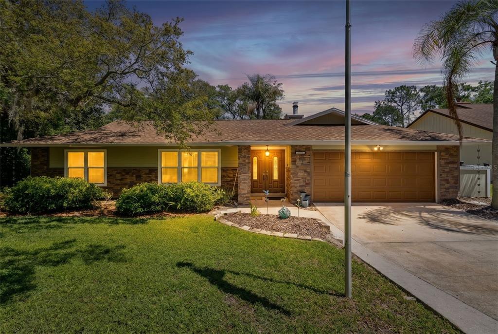 A single-story house with a stone facade, brown garage door, and a landscaped front yard — 2611 TAMERA COURT, APOPKA, FL