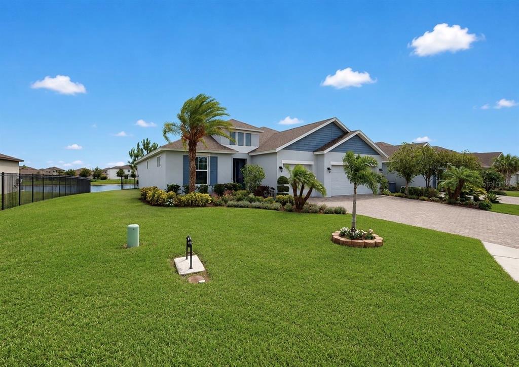 A single-story house with a blue and gray exterior, a paved driveway, and a lawn — 5206 GAVELLA COVE, PALMETTO, FL
