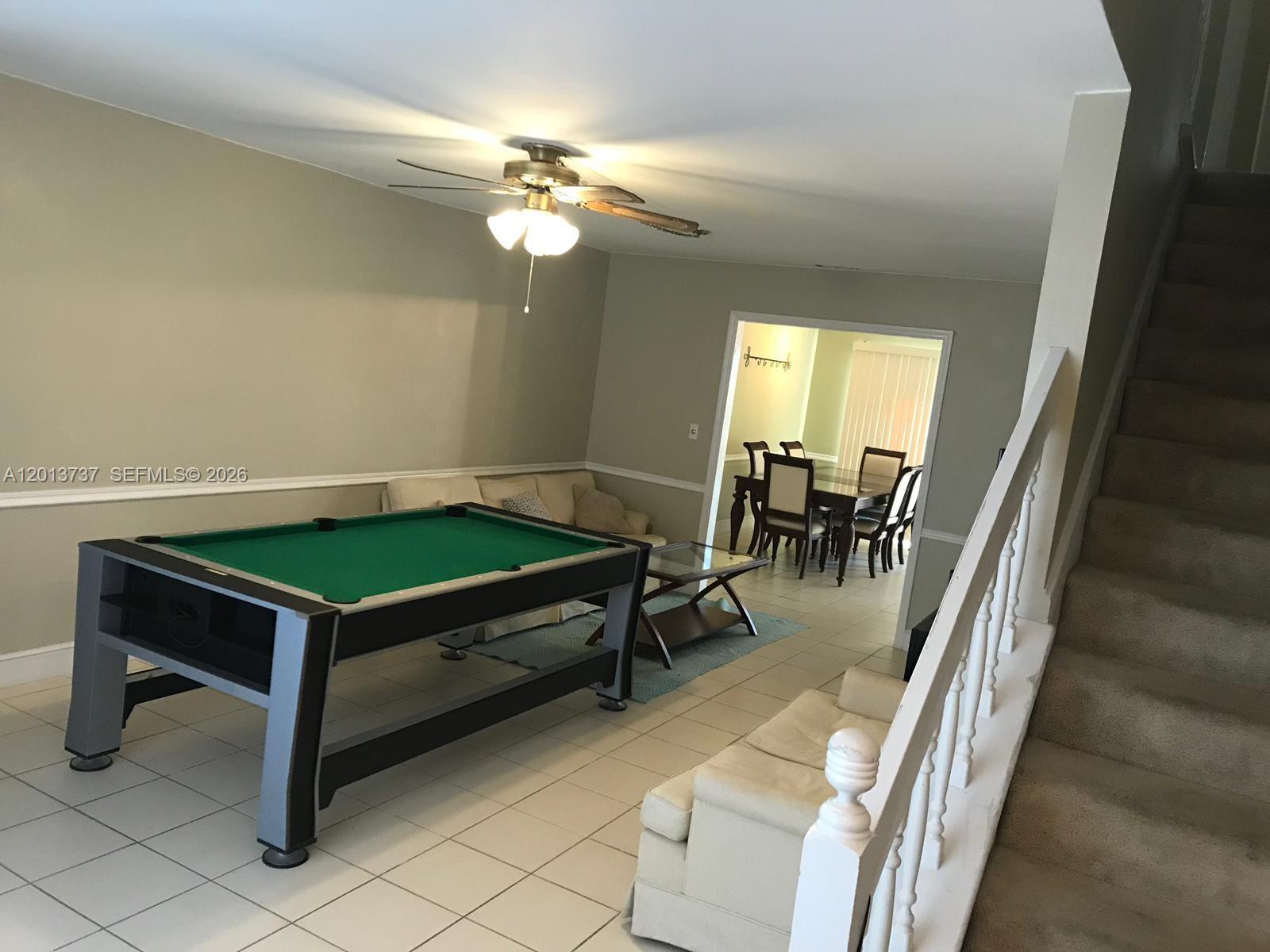 A room features a pool table, a sofa, a dining area, and a carpeted staircase — 3965 NW 9th Ave # 3, Deerfield Beach FL 33064, DEERFIELD BEACH, FL