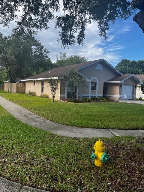 A single-story house with a tan exterior, a brown roof, and a yellow fire hydrant — 2717 WILDER PARK DRIVE, PLANT CITY, FL