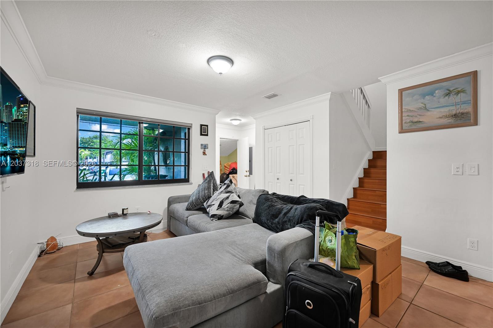 A living room features a grey sectional sofa, tile flooring, and a staircase — 15561 SW 110th Ter, Miami FL 33196, MIAMI, FL