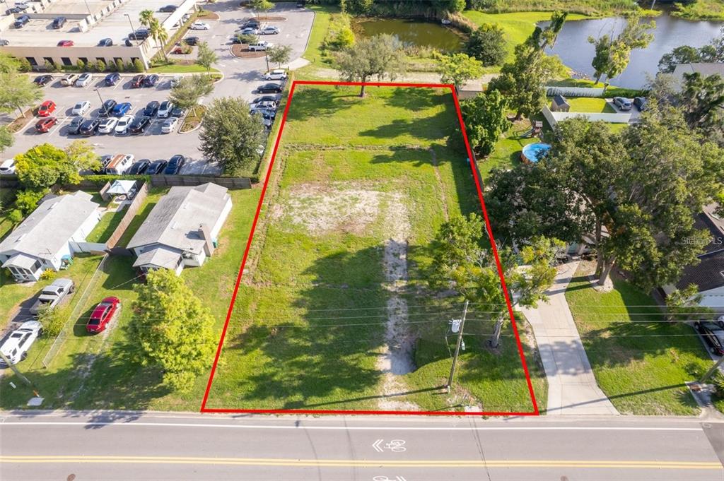An aerial view shows a rectangular vacant lot outlined in red along a paved road — 261 E CHURCH AVENUE, LONGWOOD, FL