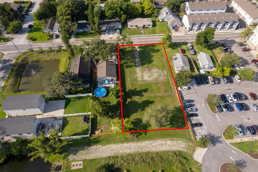 An aerial view shows a rectangular vacant lot outlined in red next to a parking lot — 261 E CHURCH AVENUE, LONGWOOD, FL