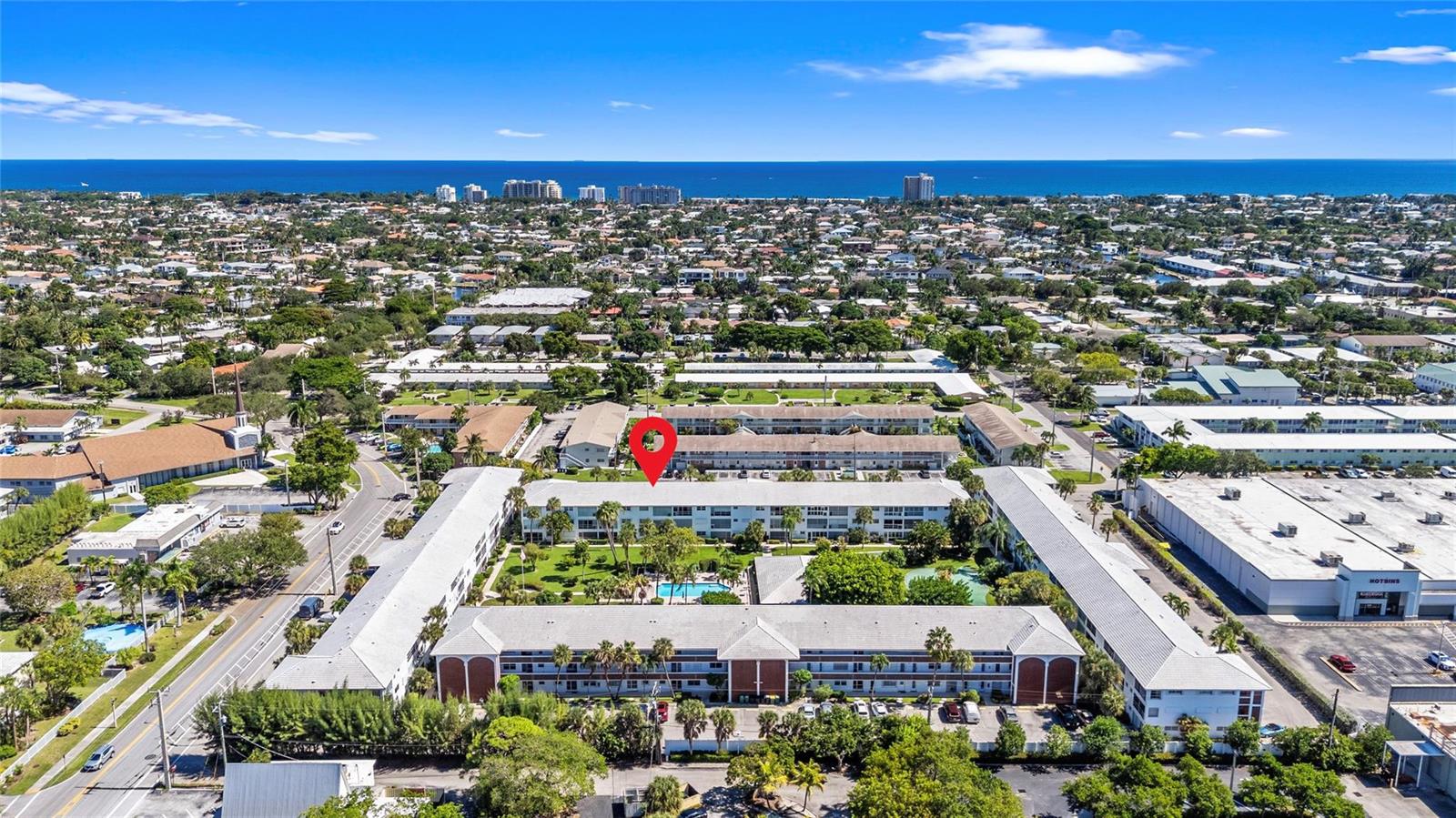 An aerial view shows a multi-story apartment complex with a central courtyard and swimming pool — 2050 NE 39th Street # 302e, Lighthouse Point FL 33064, LIGHTHOUSE POINT, FL