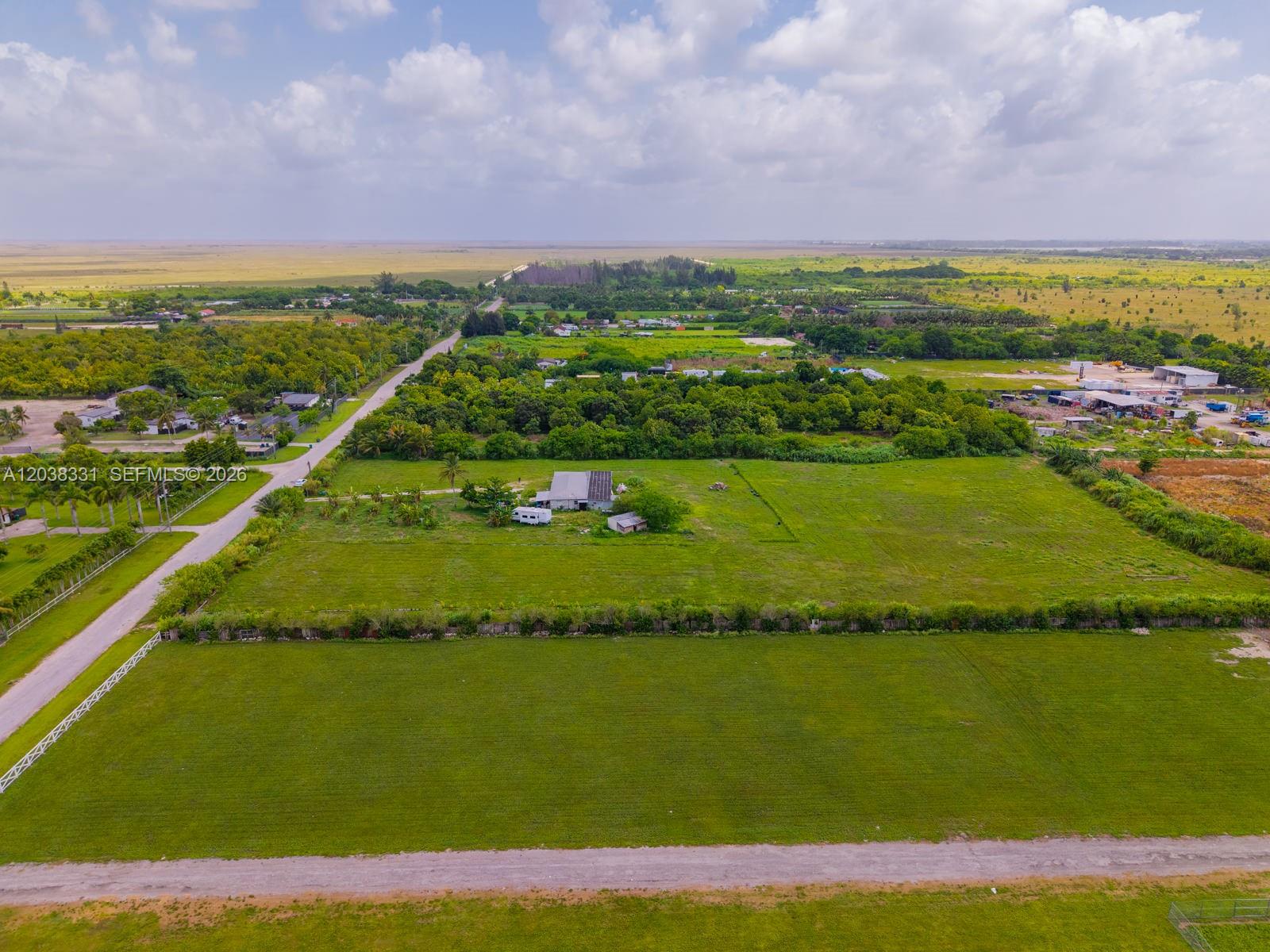 An aerial view shows a large, grassy rural lot with a house and surrounding vegetation — 12825 SW 197 AVE, Miami FL 33196, MIAMI, FL