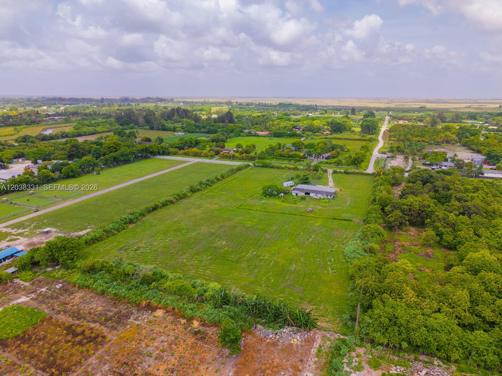 An aerial view shows a large, grassy rural lot with a small house and trees — 12825 SW 197 AVE, Miami FL 33196, MIAMI, FL