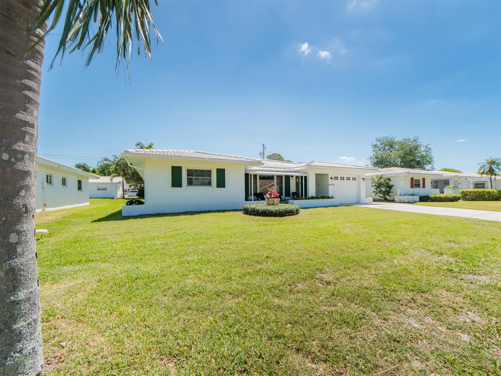 A white single-story house with a tiled roof and a large front lawn — 9227 143RD STREET, SEMINOLE, FL
