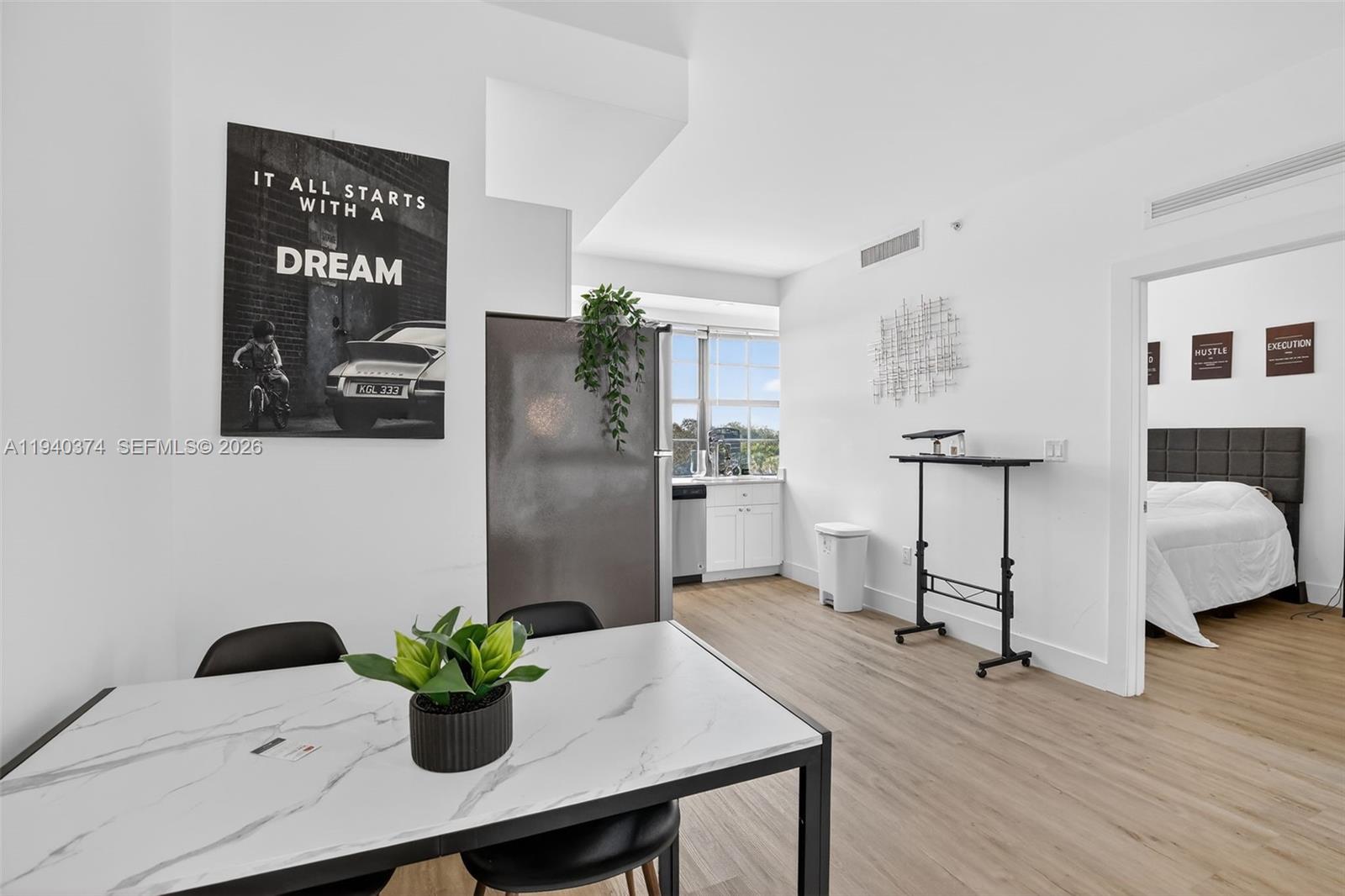 A dining area with a marble-topped table leads to a kitchen and a bedroom — 4100 SW 64th Ave # 301, Davie FL 33314, DAVIE, FL