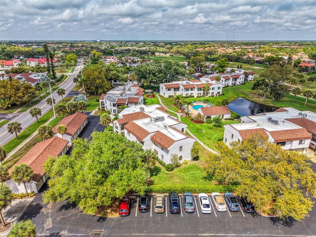 An aerial view shows a multi-building apartment complex with a pool and parking lot — 796 CAPRI ISLES BOULEVARD UNIT 130, VENICE, FL