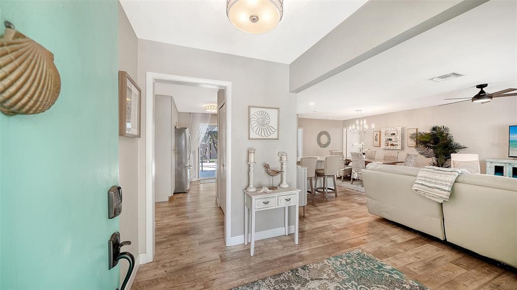 An entryway with a teal door leads into a living room with wood-look flooring — 6758 S LOCKWOOD RIDGE ROAD, SARASOTA, FL