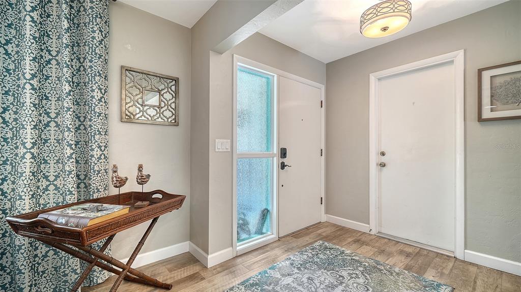 An entryway features a wooden tray table, a patterned curtain, and two white doors — 6758 S LOCKWOOD RIDGE ROAD, SARASOTA, FL