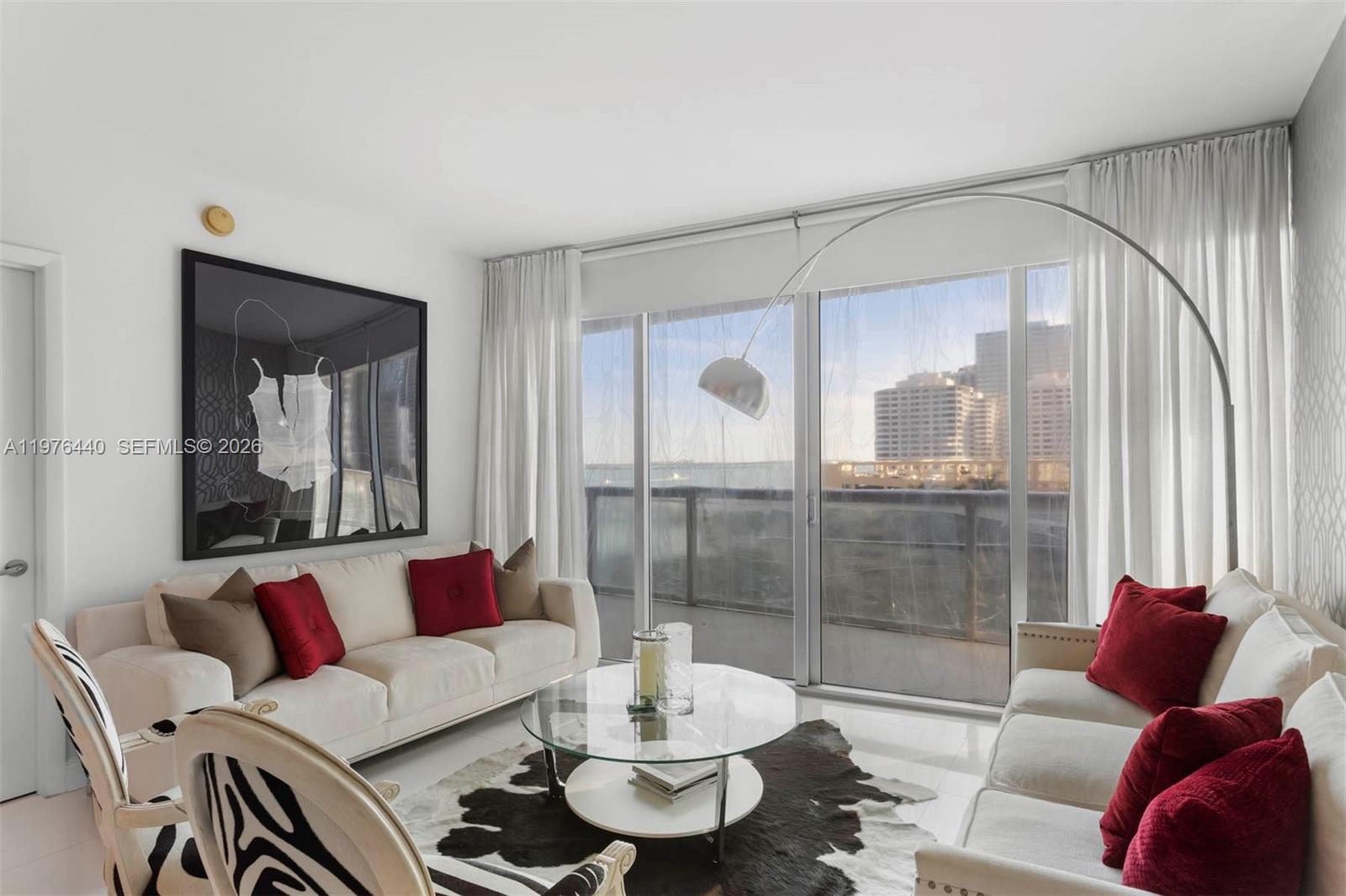 A living room features two white sofas, a glass coffee table, and floor-to-ceiling windows — 495 Brickell Ave # 805, Miami FL 33131, MIAMI, FL