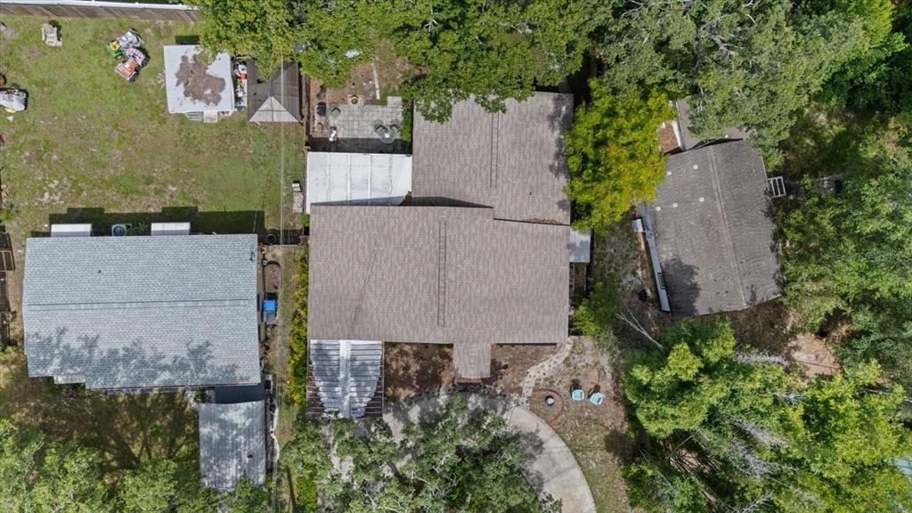 An aerial view shows a house with a brown roof, a driveway, and surrounding trees — 12510 NOREAST LAKE DRIVE, TAMPA, FL