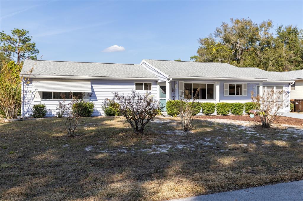 A light blue, single-story house with a gray shingled roof and a front yard — 8987 SW 108TH PLACE, OCALA, FL