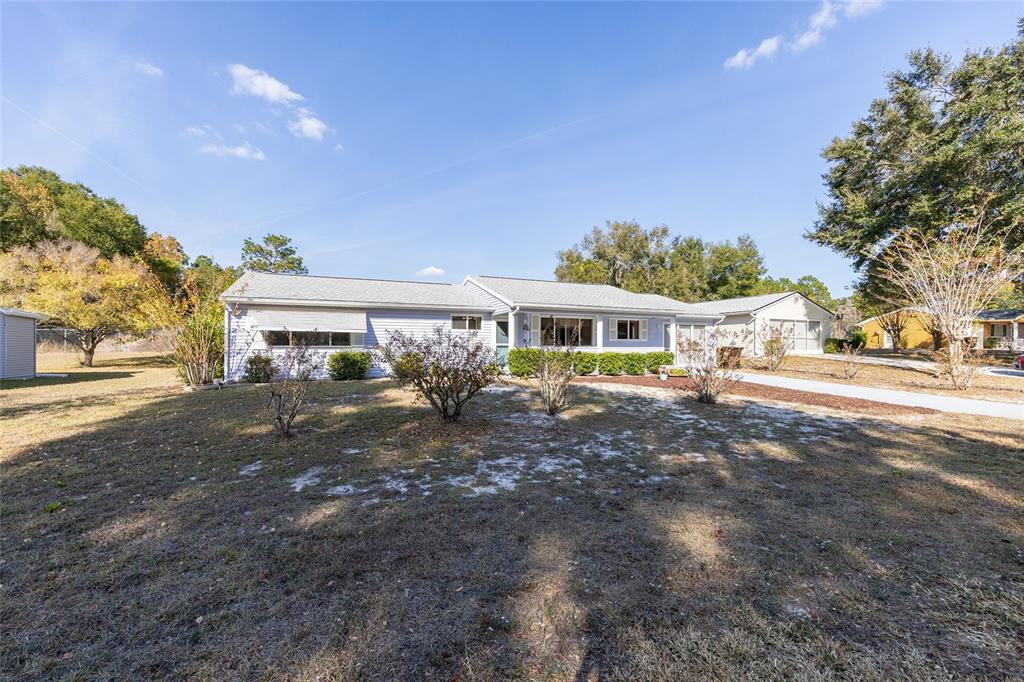 A single-story light blue house with a gray roof sits on a grassy lot — 8987 SW 108TH PLACE, OCALA, FL