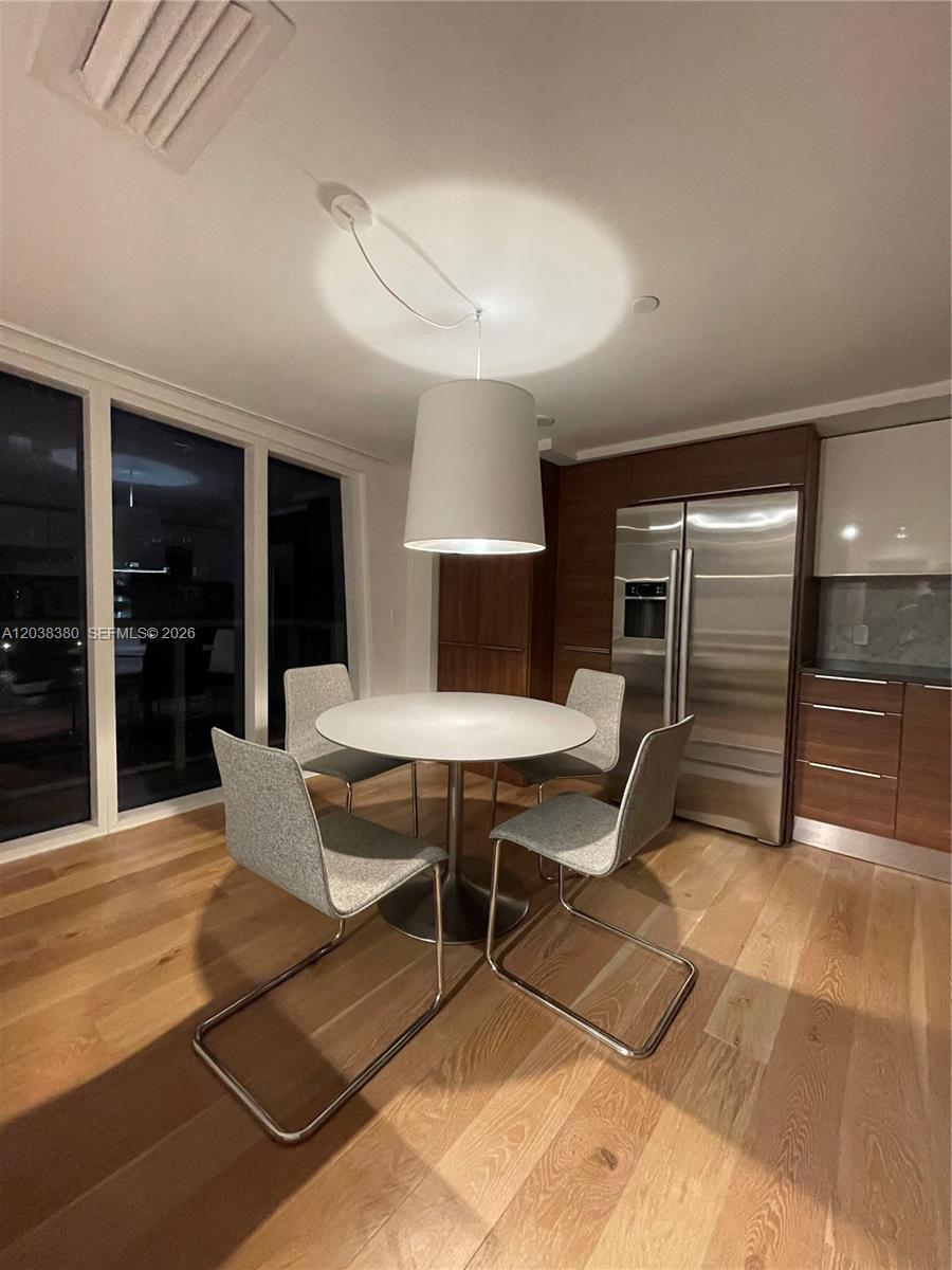 A dining area features a round table, four chairs, and a pendant light on wood floors — 601 NE 27th St # 201, Miami FL 33137, MIAMI, FL