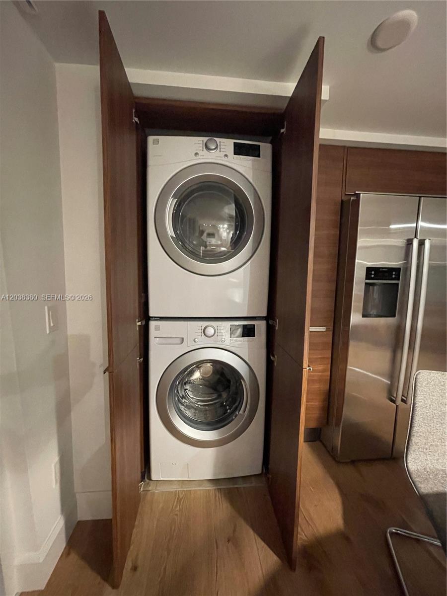 A stacked washer and dryer unit is housed inside a wooden cabinet in a kitchen — 601 NE 27th St # 201, Miami FL 33137, MIAMI, FL