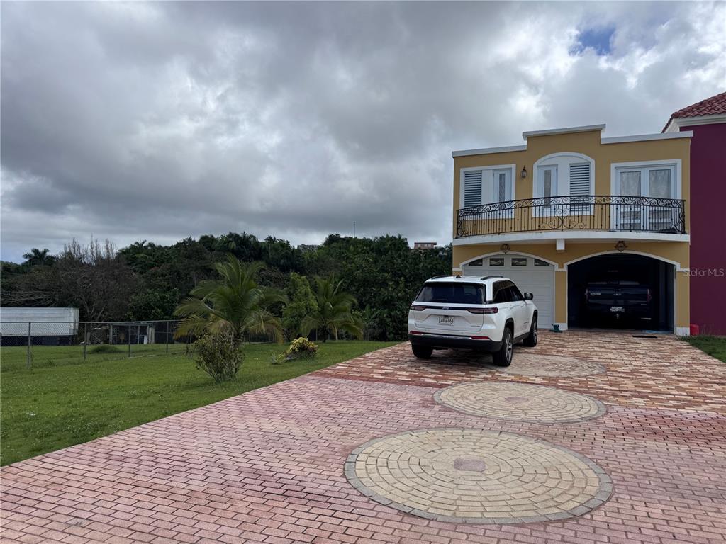 A two-story house with a paved driveway, a white SUV, and a garage — Camino Los Nieves LOS NIEVES 447 INT, ISABELA, PR