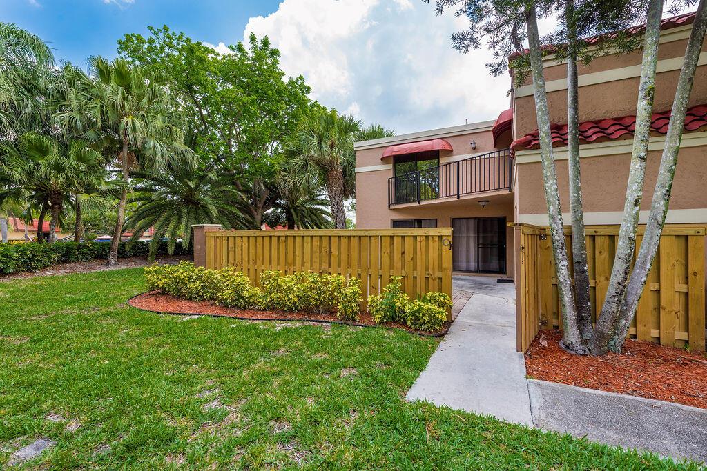 A two-story tan building with a wooden privacy fence and a small concrete patio — 8050 Severn Drive # C, Boca Raton FL 33433, BOCA RATON, FL