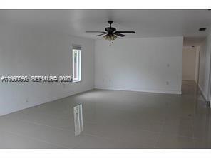 An empty room with white walls, a ceiling fan, and light-colored tile flooring — 500 NW 43rd Ct, Miami FL 33126, MIAMI, FL