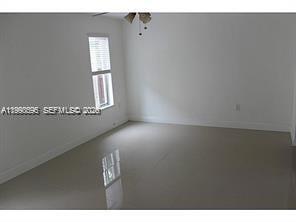 An empty room with white walls, tile flooring, and a ceiling fan — 500 NW 43rd Ct, Miami FL 33126, MIAMI, FL