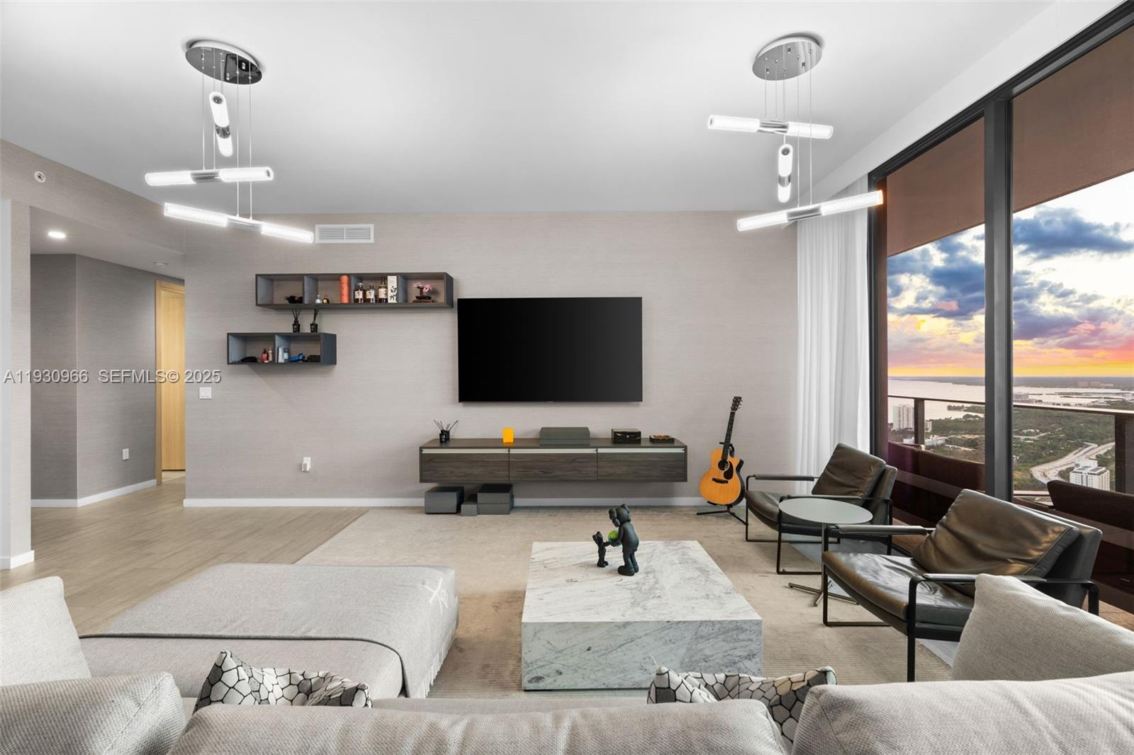A modern living room features a wall-mounted television, marble coffee table, and floor-to-ceiling windows — 1000 Brickell Plz, Miami FL 33131, MIAMI, FL