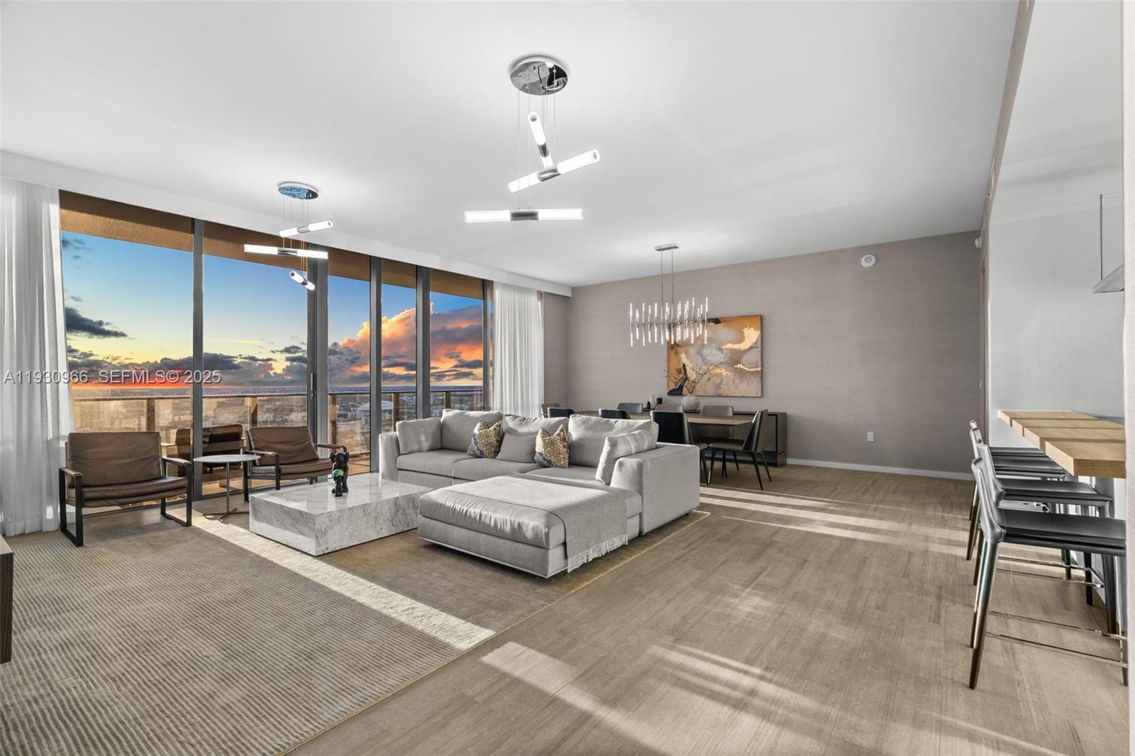 A modern living and dining area features a large sectional sofa, marble coffee table, and floor-to-ceiling windows — 1000 Brickell Plz, Miami FL 33131, MIAMI, FL
