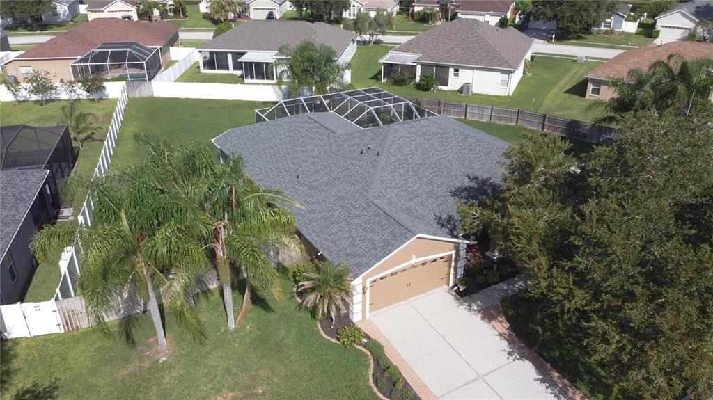 An aerial view shows a single-story house with a shingled roof, garage, and pool enclosure — 3815 RED BLUFF CT, LAND O LAKES, FL