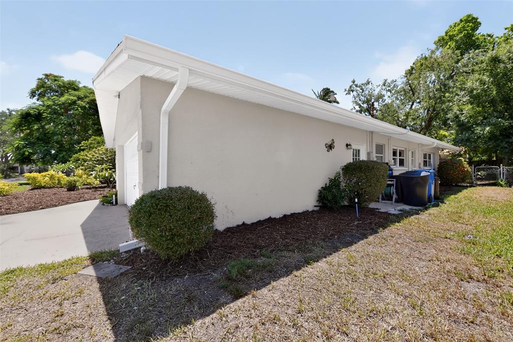 A single-story house with a white garage, a front lawn, and a white car parked outside — 100 59TH AVENUE S, ST PETERSBURG, FL