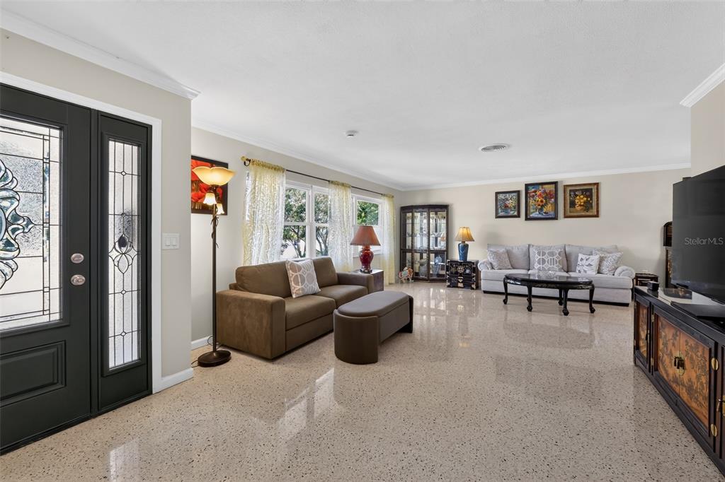 A paved patio features a large tree, a birdbath, and a screened-in porch area — 100 59TH AVENUE S, ST PETERSBURG, FL