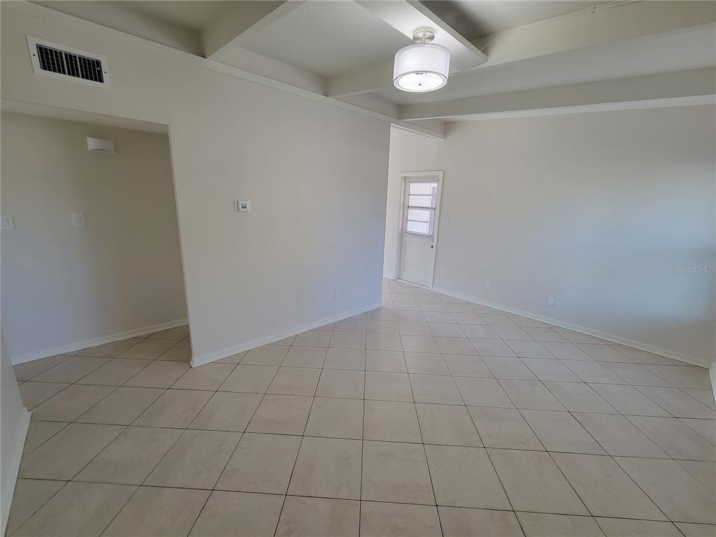 An interior room features light-colored tile flooring, white walls, and a modern ceiling light fixture — 1212 WINDERMERE WAY, TAMPA, FL