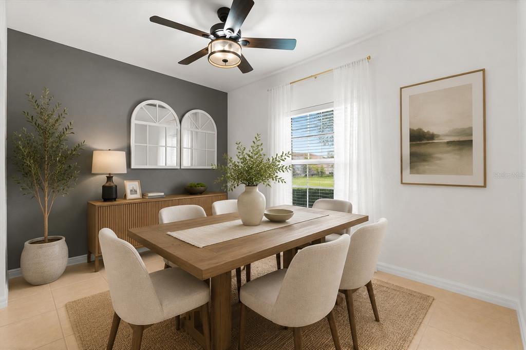 A dining room features a wooden table, upholstered chairs, a gray accent wall, and mirrors — 322 ANNABELLE WAY, DAVENPORT, FL