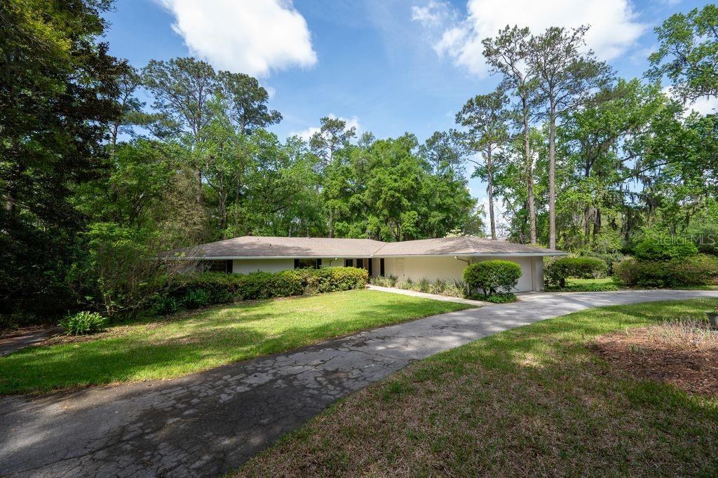 A single-story house with a long driveway sits on a wooded lot — 412 NW 46TH STREET, GAINESVILLE, FL