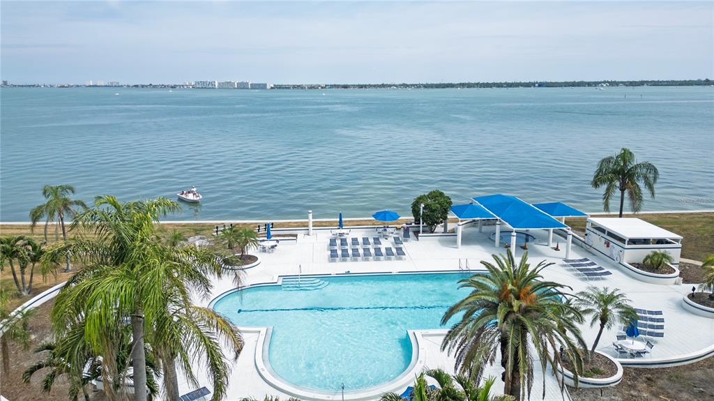 An aerial view of a swimming pool and patio area overlooking a large body of water — 5155 ISLA KEY BOULEVARD S UNIT 307, ST PETERSBURG, FL