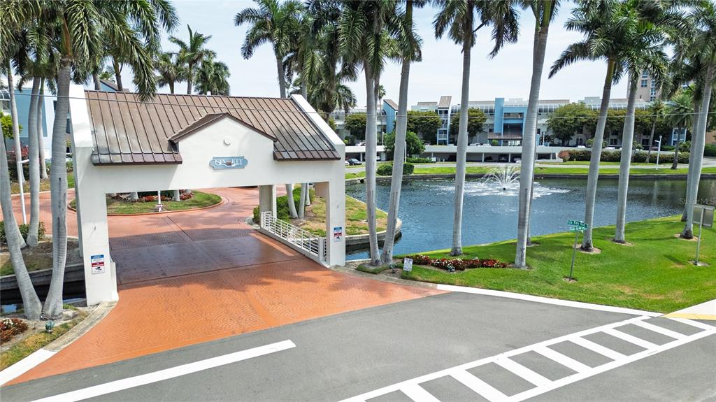 An entrance gate with a metal roof leads to a pond with a fountain — 5155 ISLA KEY BOULEVARD S UNIT 307, ST PETERSBURG, FL