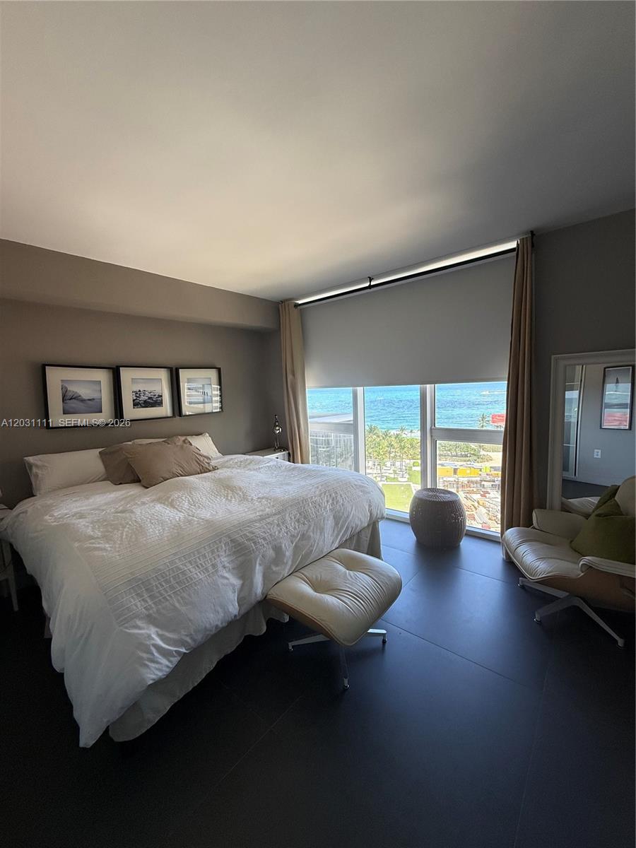 A bedroom features a bed, a lounge chair, and floor-to-ceiling windows overlooking the ocean — 10275 Collins Ave # 921, Bal Harbour FL 33154, BAL HARBOUR, FL