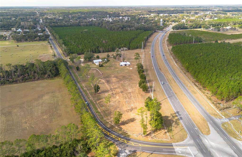 An aerial view shows a rural property situated between a highway and a local road — 1415 SE 4TH AVENUE, CHIEFLAND, FL