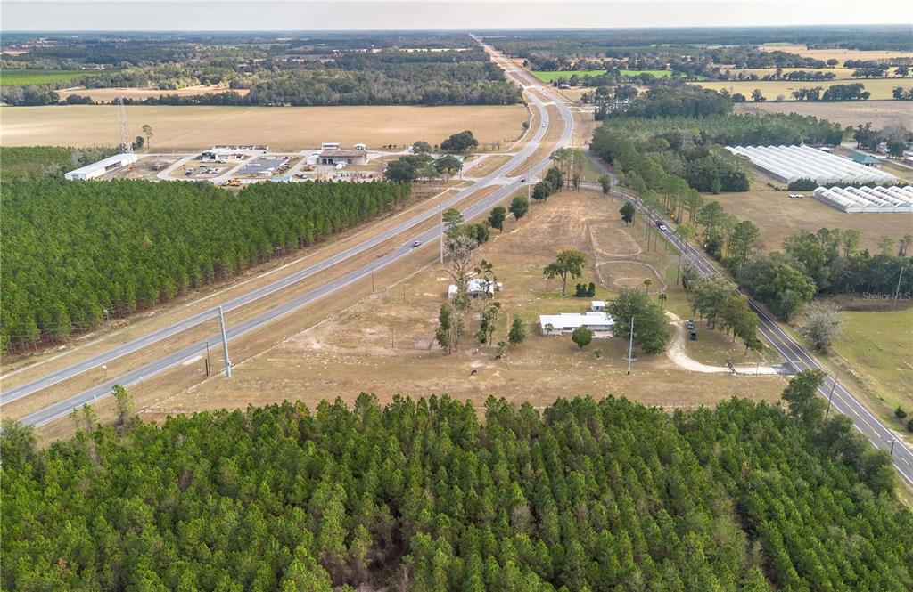 An aerial view shows a rural property with a house situated between two converging roads — 1415 SE 4TH AVENUE, CHIEFLAND, FL
