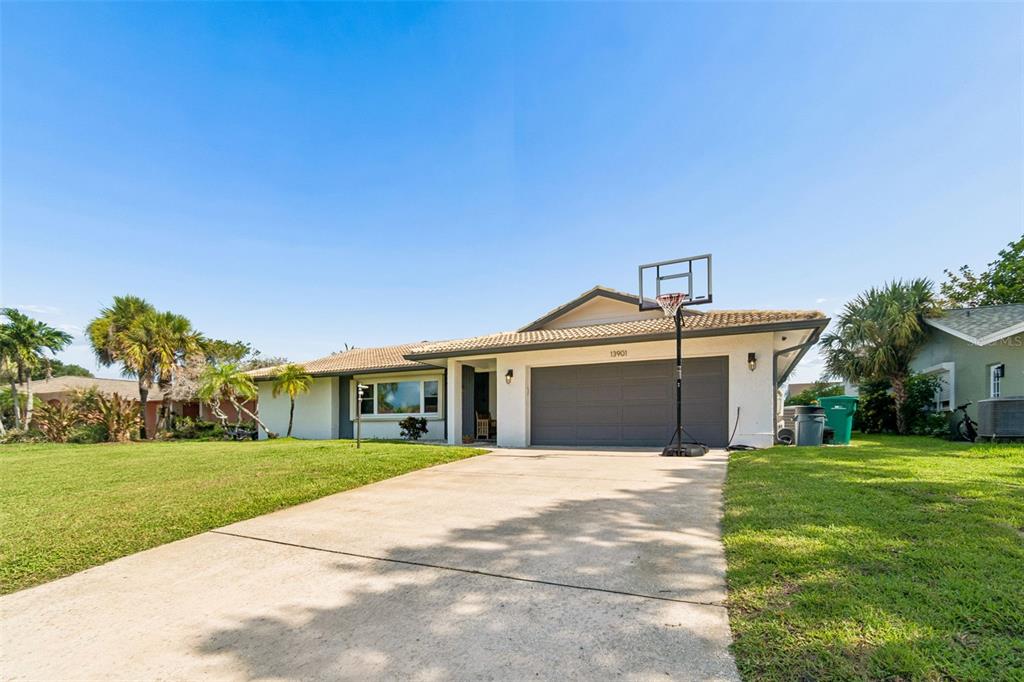 A single-story house with a concrete driveway, a two-car garage, and a basketball hoop — 13901 88TH TERRACE, SEMINOLE, FL